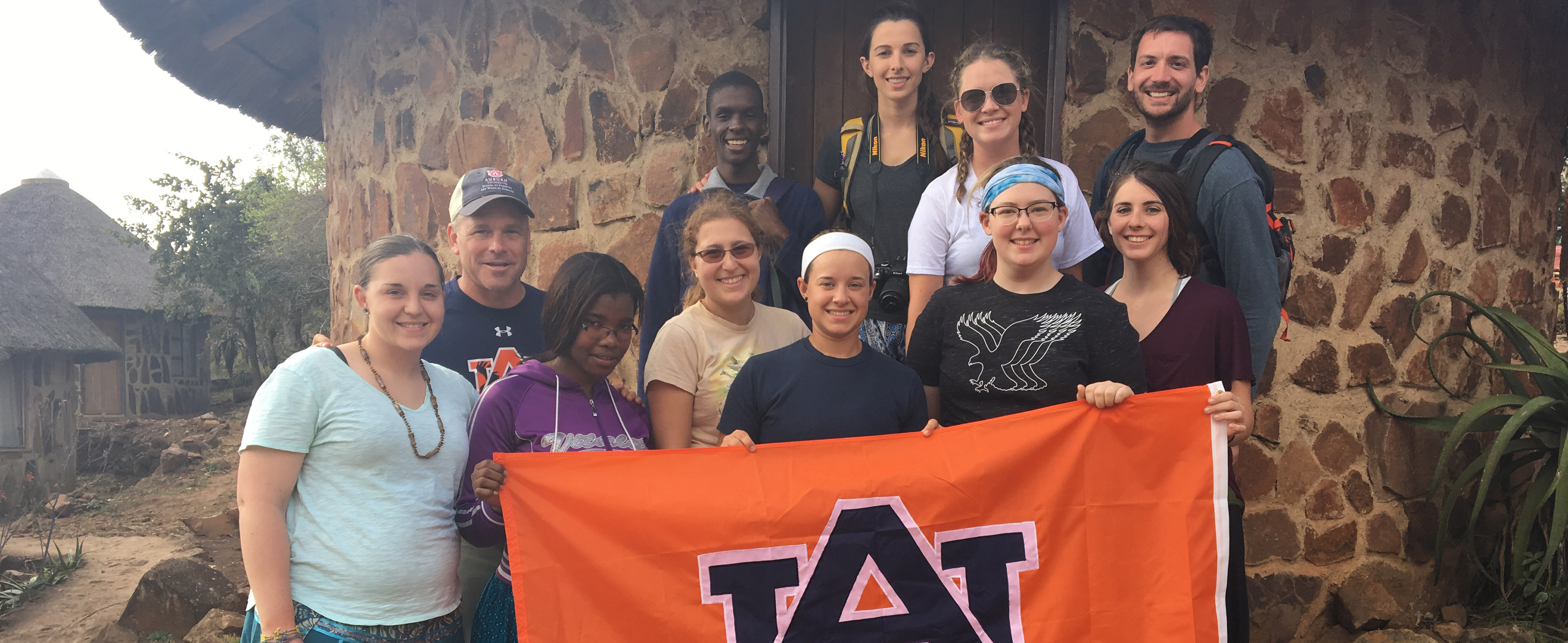 wildlife ecology and management students shown holding AU flag during a study abroad trip to South Africa